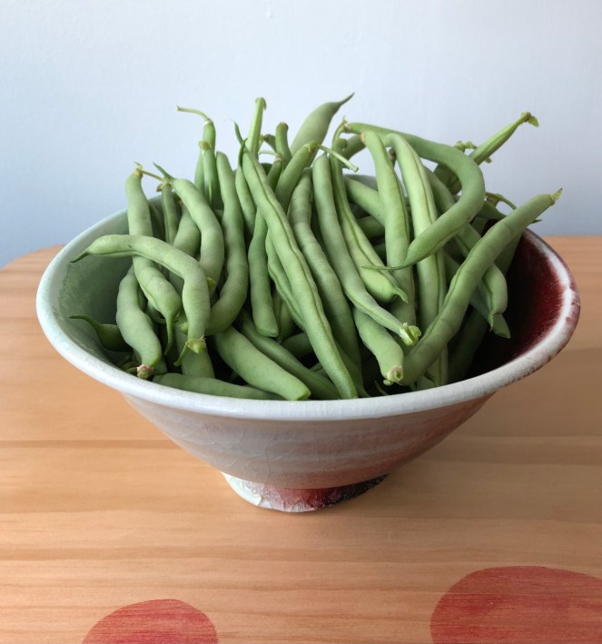 pottery bowl filled with fresh green beans