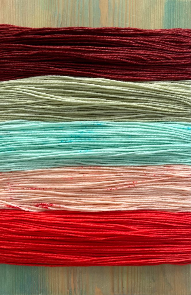 multi-colored yarn on wooden bench