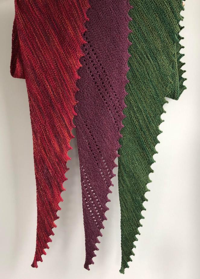 three handknit scarves in red, purple and green