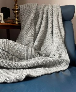 gray knit afgan on blue leather chair