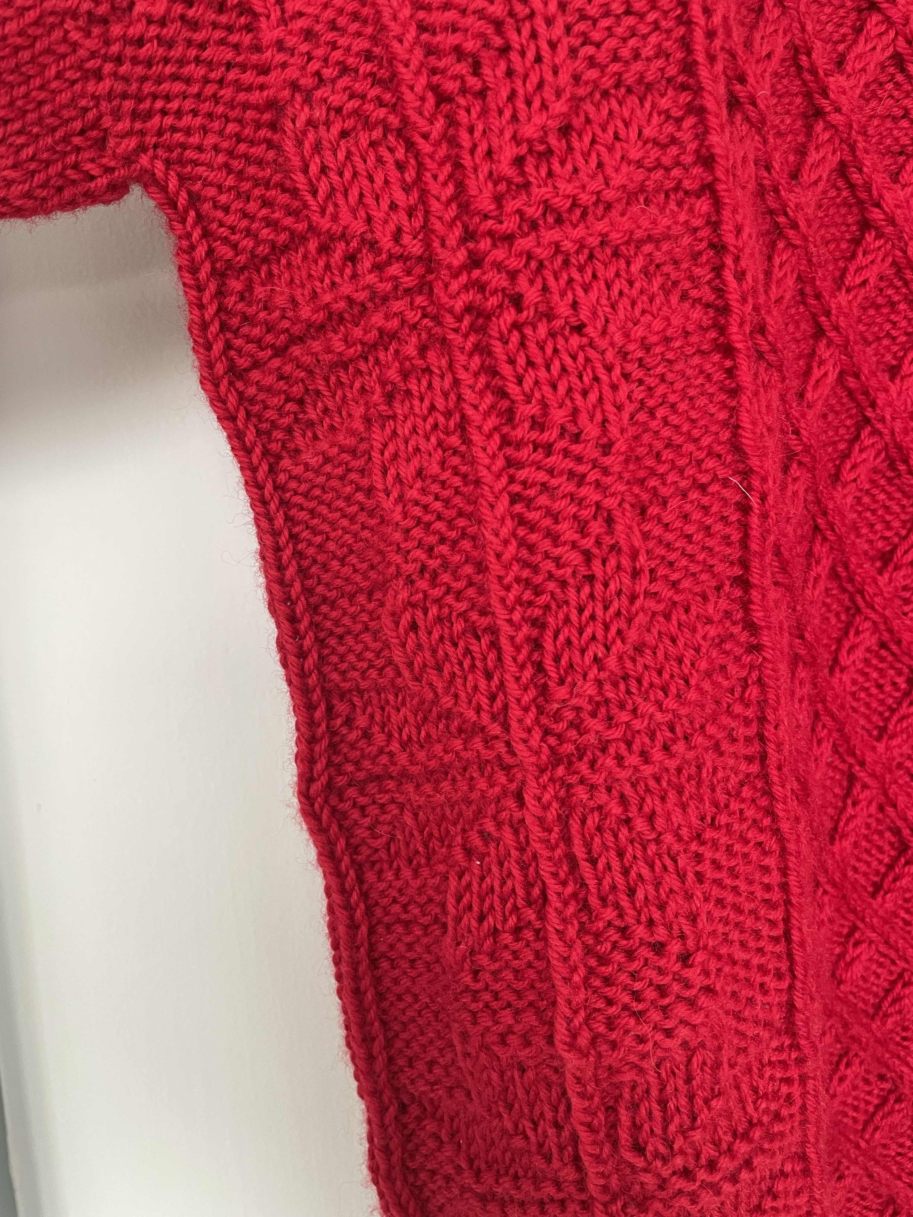 detail of star stitches on red hand knit sweater
