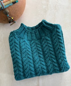 blue green sweater with cable stitched yoke