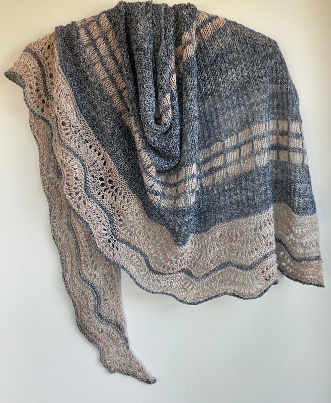 handknit blue shawl with contracting cream colored bands and lace edge