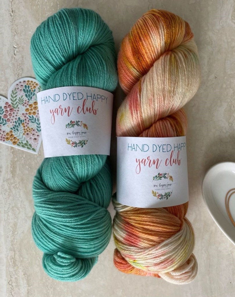 two skeins of yarn aqua on left and varigated yellow on right