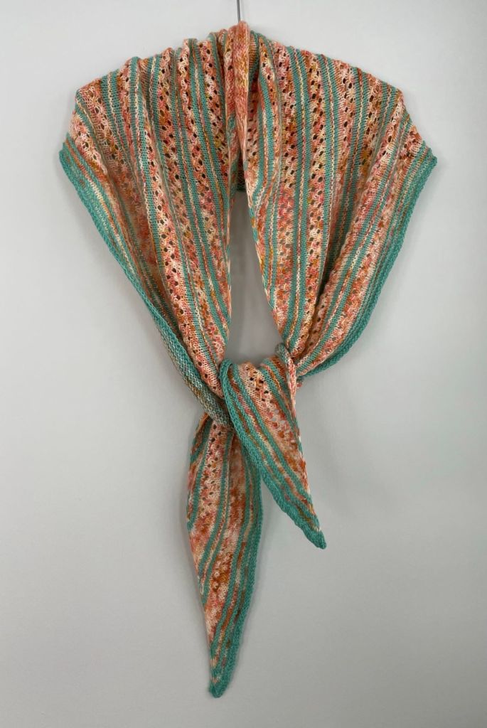 handknit aqua and coral striped shawl on hanger