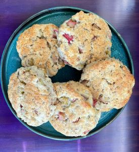 five round rhubarb scone on a blue plate on a purple background