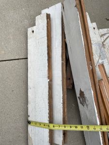 a small messy pile of white painted boards on the oncrete driveway