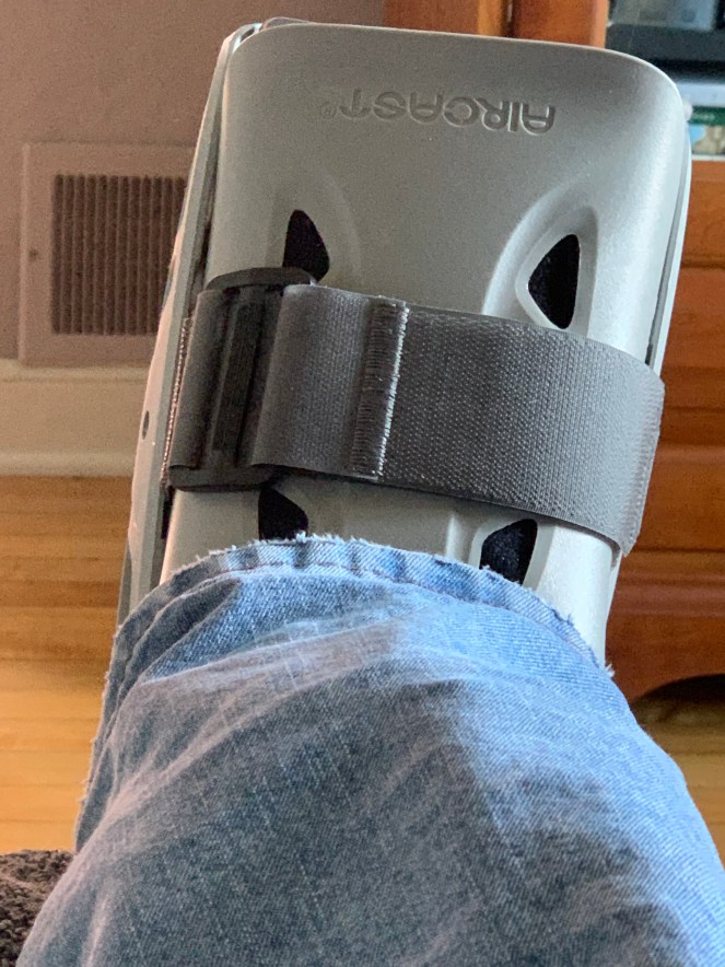 close up of a walking ankle boot and a blue jean leg