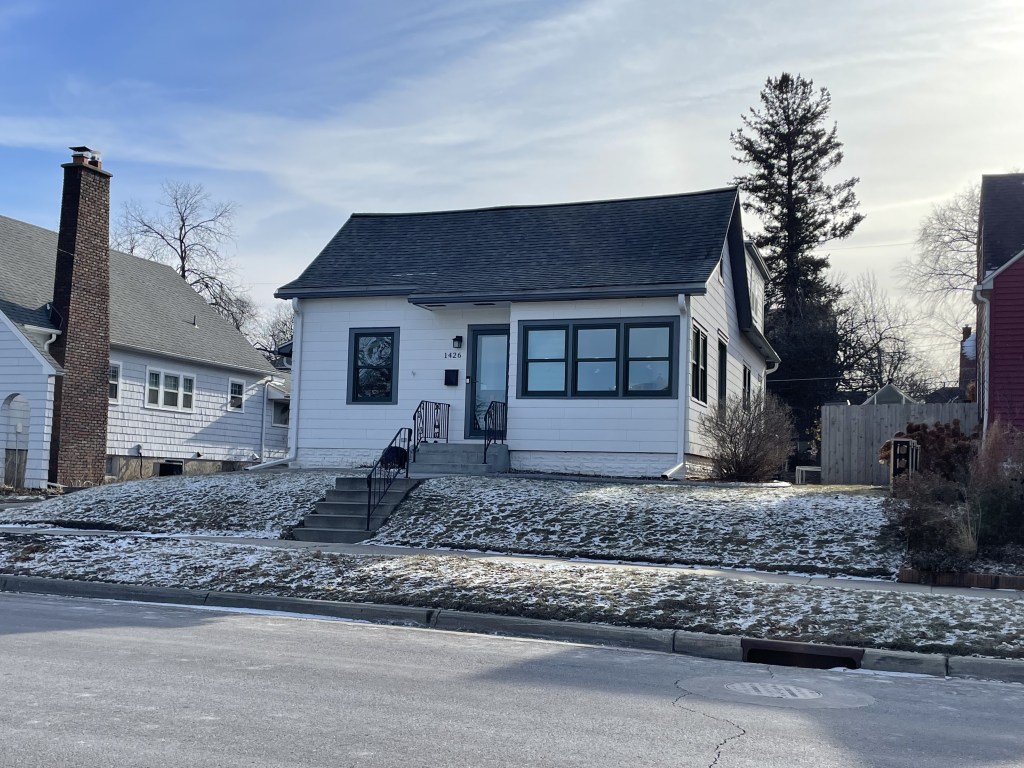 small white house with a dusting of snow on the front yard