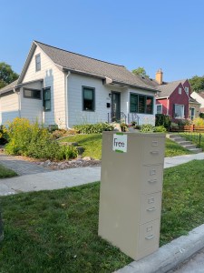 four drawer file cabinet with a free sign sitting curbside in front of a white house
