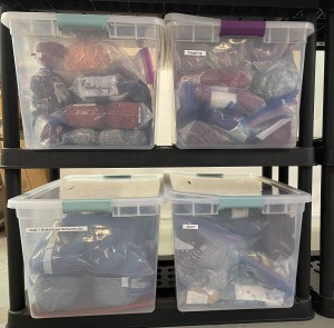 four large plastic bins filled with yarn