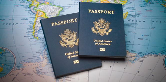 two blue US passports on a map of the world
